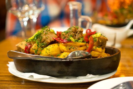 Close-up of the Georgian national dish ojakhuri with meat and vegetables in ketsi on the table in the restaurant. Selective focus