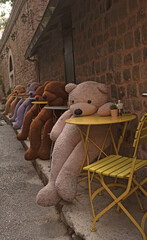 Plush bears sitting  at at coffee’s chairs
