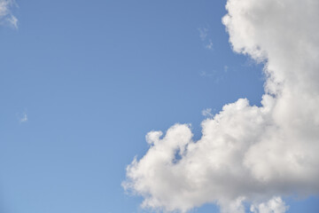 Backdrop of a white cloud in a blue summer sky. Natural background with soft clouds.
