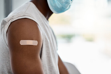 Closeup, bandage and covid vaccine for black man with mask for healthcare, wellness or safety. Man...