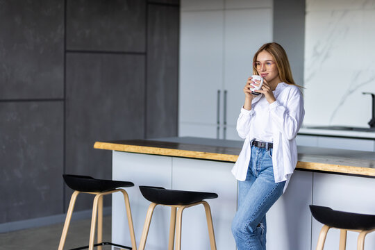 Young Woman Drinking Coffee On The Kitchen In The Morning.