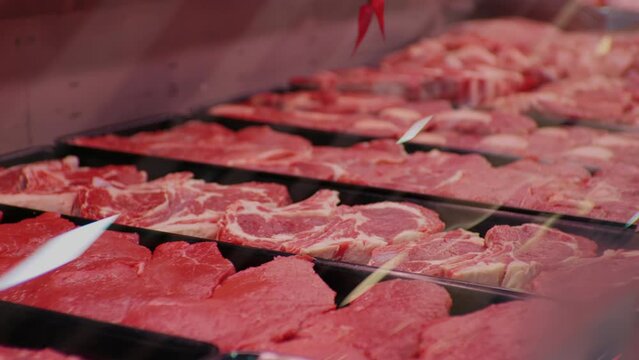 Large selection of fresh raw meat cuts in butchers shop. Freshly cut meat hunks for sale in supermarket.
