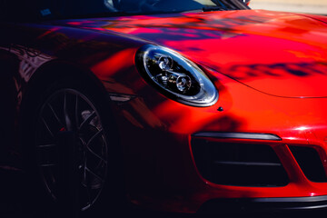 Fototapeta na wymiar Luz de um carro desportivo vermelho à sombra