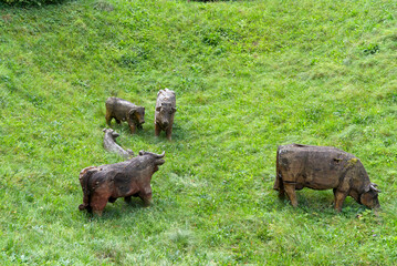 Wooden cows at castle ditch grazing on a cloudy late summer day. Photo taken September 1st, 2022, Kyburg, Switzerland.