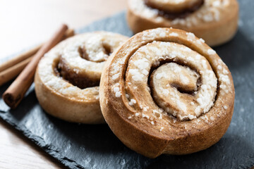 Fototapeta premium Cinnamon rolls buns on wooden table. Kanelbulle Swedish dessert