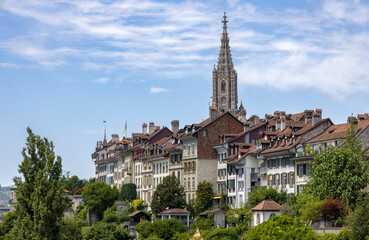 Fototapeta na wymiar BERN, SWITZERLAND, JUNE 23, 2022 - View of the old buildings and the bell tower of the Bern's Cathedral in the center of Bern, Switzerland