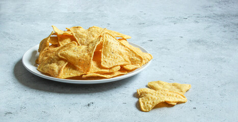 White plate with corn chips nachos on the concrete background. Mexican nachos.