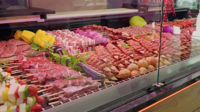 Display window butchers shop with meat arrangment either for grill or barbeque. Raw piece of meat beef steak and turkish kebab . Food industry meat for sale.