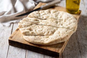 Italian focaccia with rosemary on wooden table