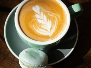 Cappuccino served with blue macaron. Close up