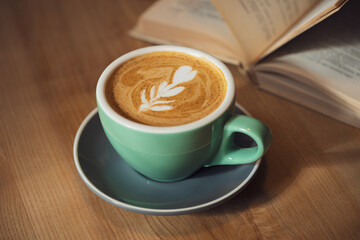 Cappuccino on the table next to the book