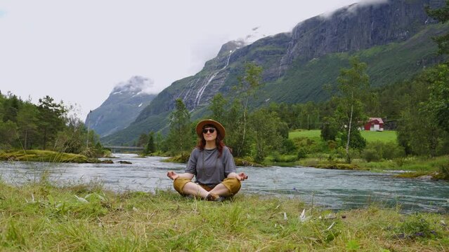 Travel woman is doing meditation in Norway Lovatnet