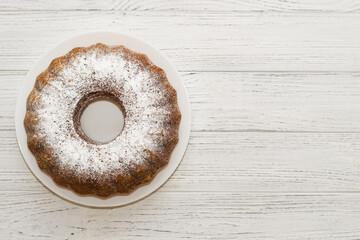 The baked dessert is a round cupcake sprinkled with powder.
