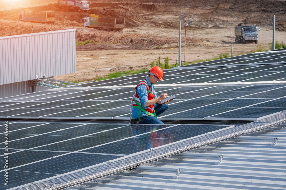 Aufkleber Professional worker installing and checking solar panels on the roof of a factory,Innovative solution for energy solving. Use renewable resources. Green energy.