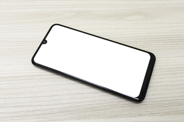 Celular com a tela transparente sobre uma mesa de madeira © DR Moura