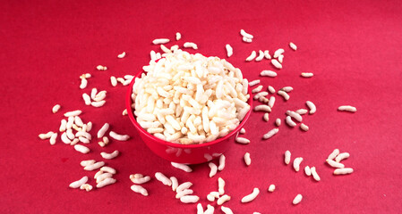 puffed rice inside wooden bowl with puffed rice resting on white background with top view