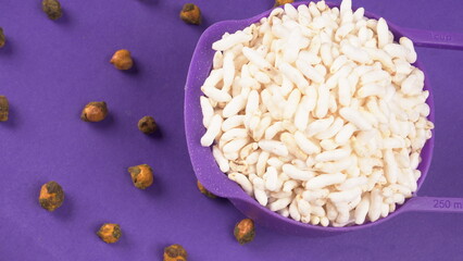 puffed rice inside wooden bowl with puffed rice resting on white background with top view