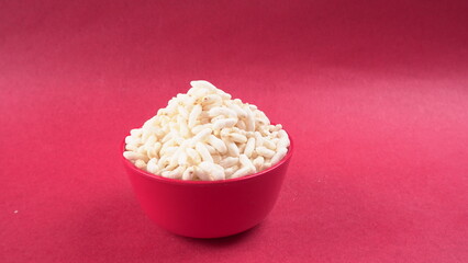 puffed rice inside wooden bowl with puffed rice resting on white background with top view