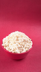 puffed rice inside wooden bowl with puffed rice resting on white background with top view