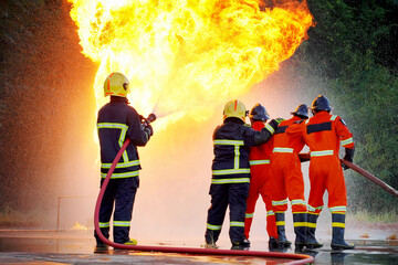 irefighters using Twirl water fog type fire extinguisher to fighting with the fire flame from oil...