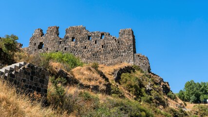 Fototapeta na wymiar Armenia, Amberd, September 2022. The ruins of the walls of an ancient fortress on the mountain.