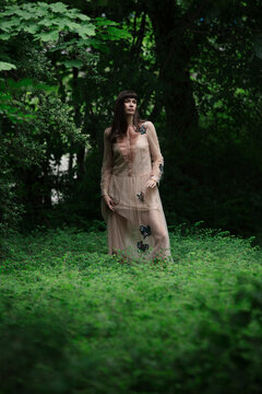 Female model, wearing dress while standing in nature with sensuous expression. Munich, Germany