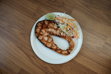 Delicious grilled Teriyaki salmon steak with salad for healthy style dinner.