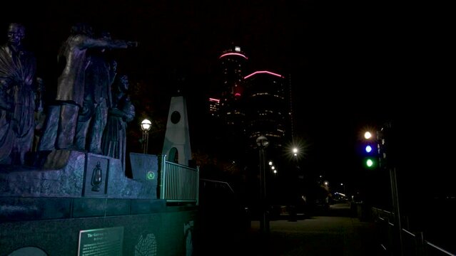 Renaissance Center in Detroit, Michigan at night with gimbal walking forward along riverwalk.