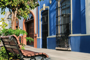 Wooden bench and buildings on city street