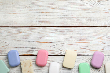 Many different soap bars on wooden table, flat lay. Space for text