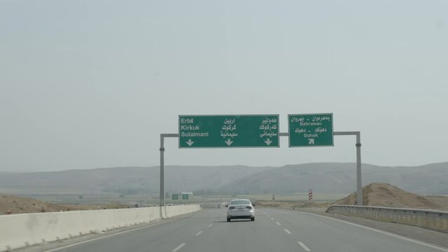 Driving past a highway sign in Kurdistan Iraq for Erbil, Kirkuk, Sulaimani, and Duhok
