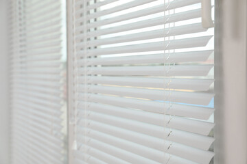 Stylish window with horizontal blinds in room, closeup
