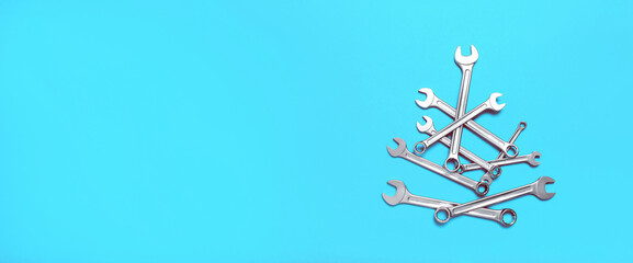 Christmas tree made of wrenches on a blue background. New Year banner with tools. Postcard with place for greeting text for happy new year with industrial holiday concept. Close-up