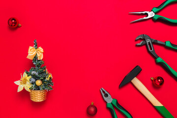 Fototapeta na wymiar A set of quality green building tools to repair a car or house and Christmas tree on a red background. Do it yourself instruments. Banner for a New year advertise construction shop with copy space