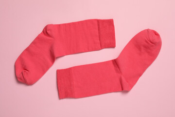 Pair of new socks on pink background, flat lay