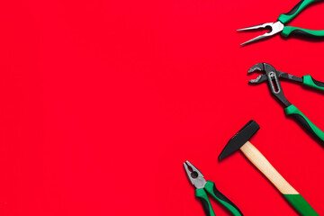 A set of quality green building tools to repair a car or a house on a red background. Do it yourself instruments. Banner for advertising construction shop with copy space. Business card