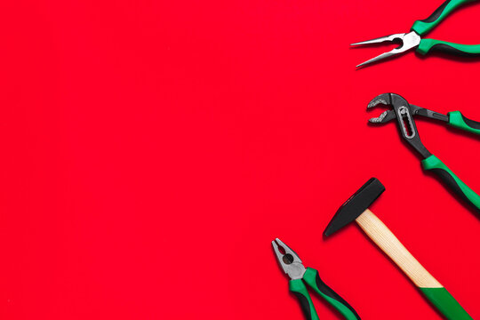 A set of quality green building tools to repair a car or a house on a red background. Do it yourself instruments. Banner for advertising construction shop with copy space. Business card