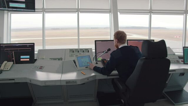 Male Air Traffic Controller Talk using microphone in Airport Tower. Realtime