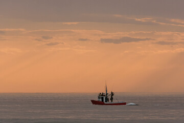 A small fishing boat returning to port at sunset, Maspalomas, Gran Canary, Canary Islands, Spain