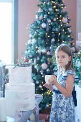 a girl sitting in a room with Christmas decoration