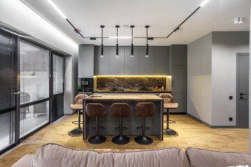 Modern luxury apartment with a free layout in a loft style in gray and dark colors. Stylish kitchen...