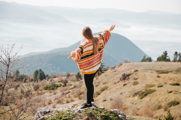 Obraz premium Woman standing on the rock among the mountains at sunny day in the forest in Turkey Bolu. Hiking concept.