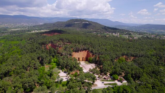 Aerial: far away panoramic shot of the amazing french landscape with one of the historic french mines inside the mountains view.