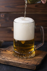 fresh cold beer in a glass on wooden board