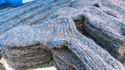 Knitwear made of natural wool. Wool socks for cold weather. Handmade products made of natural wool. Sale of warm clothes for winter.