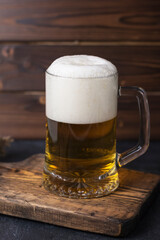 fresh cold beer in a glass on wooden board