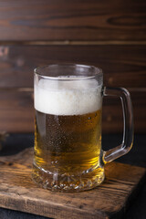 fresh cold beer in a glass on wooden board