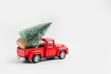 Miniature red car with Christmas tree. Winter cute landscape. Cozy small world. Christmas decorations, holiday concept. Merry Christmas!