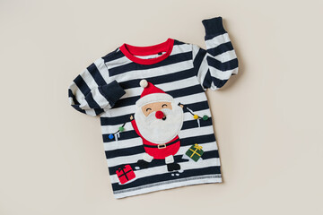 Childrens jumper with Santa Claus. Kids clothes and accessories for Christmas party. Fashion baby clothes. - obrazy, fototapety, plakaty