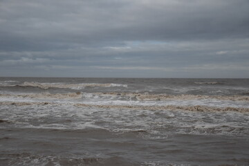 Waves crashing onto the beach and sea wall during high tide. Taken in Cleveleys Lancashire England. 